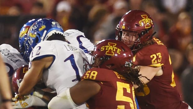 Cyclones linebacker Mike Rose and defensive end Eyioma Uwazurike take down Kansas wide receiver Torry Locklin. Syndication The Ames Tribune